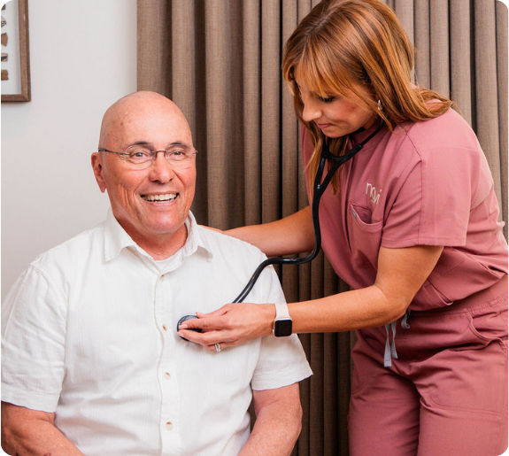 Nurse uses stethoscope to listen to patient's heart